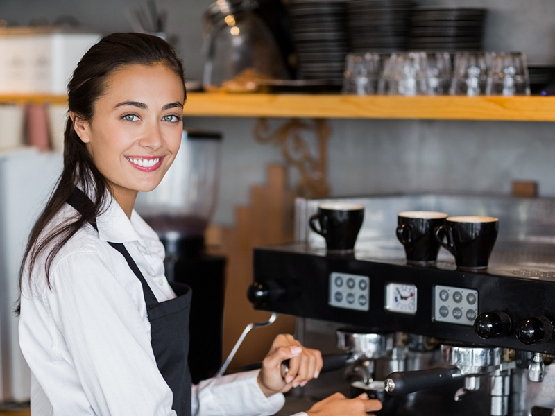 Woman barista making coffee